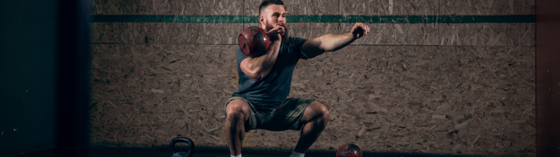 nexo_man squatting with kettlebell