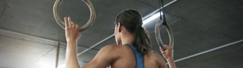 nexo_woman doing pull ups on rings