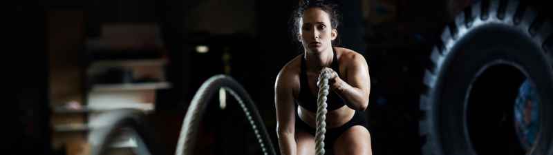 nexo_woman exercising with ropes in gym