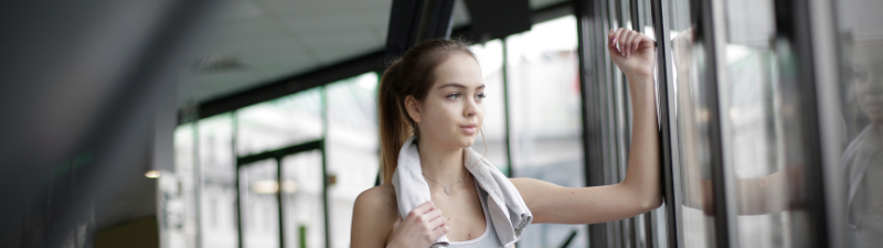 nexo_woman looking out gym window